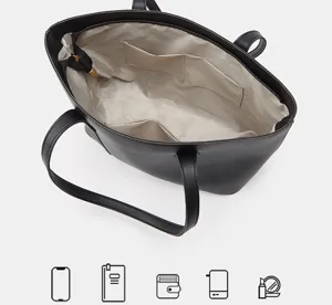 Vista interior detallada del bolso tote negro que muestra gran capacidad y bolsillos