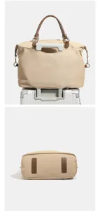Detail view of the travel duffel bag showing the suitcase sleeve and bottom protective patches.