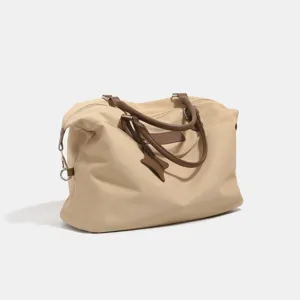 Large capacity beige canvas travel duffel bag with brown leather handles and classic design.