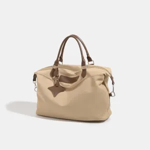 Large capacity beige travel duffel bag with brown leather handles and classic design style for women.