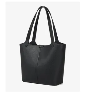 Detailansicht der schwarzen Ledertasche, feine Narbenstruktur und stabile Doppelgriffe.