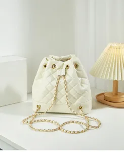 Detailed close-up view of elegant white quilted bucket bag with gold chain strap.