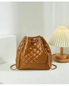 Chic brown quilted bucket bag with gold chain strap, stylish commuter shoulder bag.