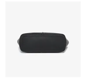 Unterer Detailblick auf die schwarze Ledertasche, der einen stabilen flachen Boden zeigt.