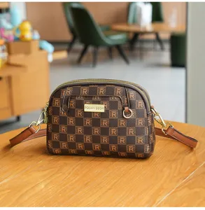 Stylish brown printed dome crossbody bag, vintage grid design with adjustable strap.