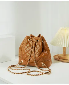 Brown quilted bucket bag detail shot showcasing luxury chain strap and soft faux leather texture.