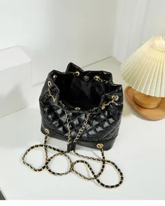 Detailed view of black quilted bucket bag with gold chain strap, chic and elegant design.