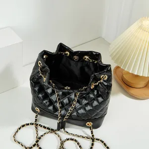 Black quilted bucket bag with gold chain strap, stylish commuting shoulder bag for women.