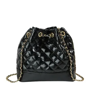 Black quilted bucket bag with gold chain strap, stylish leather shoulder handbag for women.