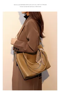 Brown leather tote bag featuring a chic plaid ribbon, offering large capacity for daily use.