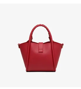 Detailed view of the red leather bucket bag, featuring exquisite clasp and handle design.