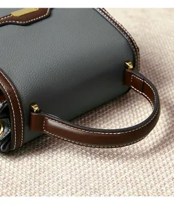 Women stylish top-handle shoulder bag with contrast color stitching and metal hardware detail.