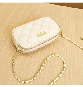 Chic quilted small square crossbody bag with double zippers, gold chain strap, and elegant design.