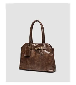 Detailed view of vintage brown shell handbag, classic metal buckle and sturdy handle design.