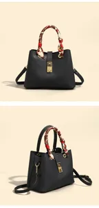 Detail view of black leather handbag with scarf handle and gold hardware lock, elegant chic.