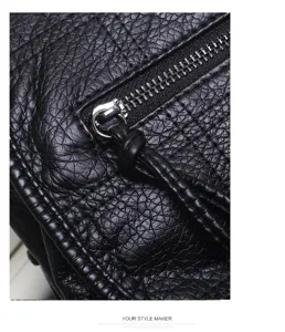 Close-up detail of black soft leather backpack showing texture, metal zipper and puller.