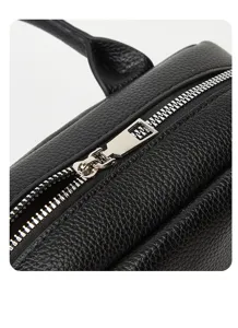 Close-up detail of black leather handbag with silver metal zipper, showing premium texture.