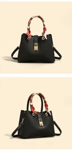 Detailed view of black luxury tote bag with floral twilly scarf and gold hardware accents.