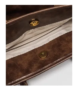 Handbag interior detail showcasing retro brown leather, durable lining, and vintage bronze snap.