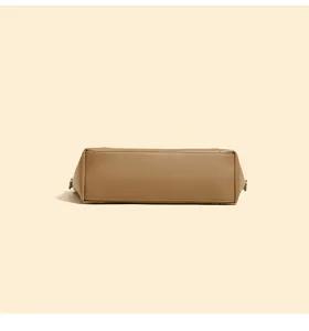 Detailed bottom view of a minimalist khaki faux leather handbag, showing neat stitching.