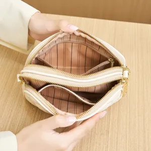 Beige quilted multi-layer zipper crossbody bag with classic striped interior lining.