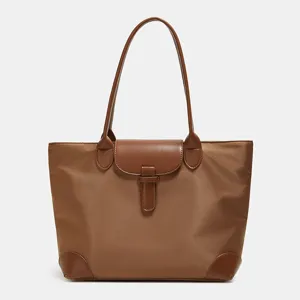 Classic brown nylon tote bag with leather handles and flap closure for women commuting daily.