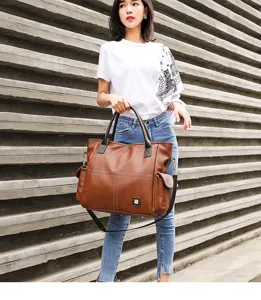 Closeup view of the large brown leather tote bag showcasing shoulder strap and classic design.