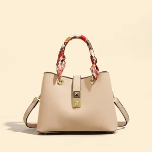 Fashionable niche design beige tote bag with chic silk scarf handle and metal lock detail.