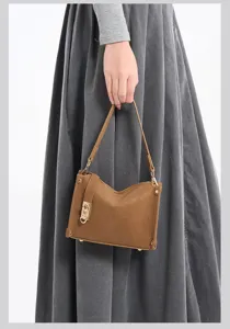 Detailansicht der braunen Handtasche aus Mattleder mit Metallverschluss und Schulterriemen.