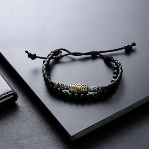 Primo piano dettagliato del bracciale in pelle intrecciata con perline tibetane e distanziatori.