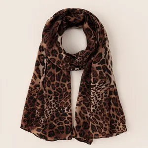 Detalle de bufanda de gasa con estampado de leopardo y patron animal en tela ligera transparente.