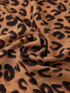 Primer plano detallado de tela de gasa con estampado de leopardo clásico, caída y textura suave.