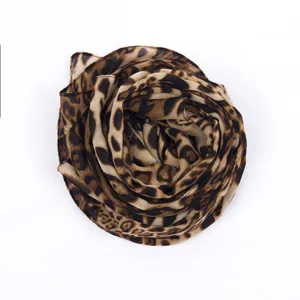 Vista detallada del elegante pañuelo de gasa con estampado de leopardo y textura fina.