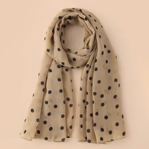Detalle de un pañuelo beige de gasa para mujer con lunares negros diseño elegante.
