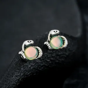 Detailed macro shot of stylish snake magnetic ear clips featuring a glowing opal sphere.