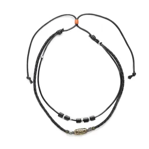 Primo piano dettagliato di collana in corda di cera intrecciata con perlina tibetana.