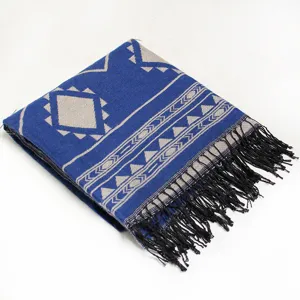 Detailed view of the blue geometric knit tassel scarf, cozy winter shawl and cape for women.