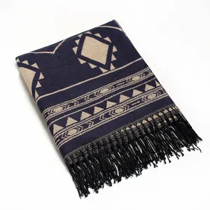 Detailed shot of navy blue geometric patterned scarf with black fringe and cozy warm texture.