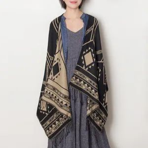 Detailed view of the women geometric pattern poncho shawl with cozy tassels and warm knit fabric.