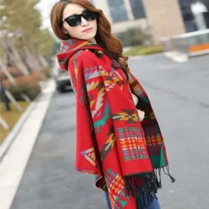 Close-up detail of the ethnic style geometric pattern and tassel on the red hooded cape.