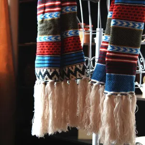 Detailansicht des ethnischen Boho Winter Strickschals mit Fransen und kuscheliger Wollstruktur.