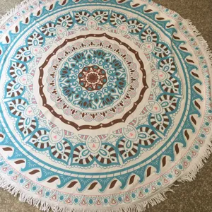 Ronde strandhanddoek voorzien van ingewikkelde mandalapatronen en fijne franjes.
