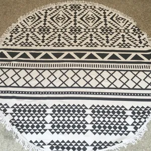 Gedetailleerd close-up van de ronde zwart-witte strandhanddoek met geometrisch patroon.