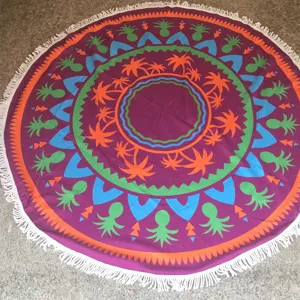 Rond strandhanddoek detail met levendig tropisch palmboom en ananas patroon en franjes.
