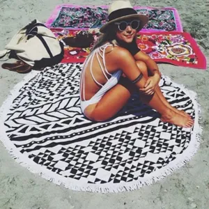 Ronde strandhanddoek met zwart-wit geometrisch patroon en franjes voor de zomervakantie.