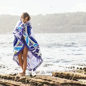 Gedetailleerd overzicht van een ronde strandhanddoek met blauw mandalapatroon en franjes.