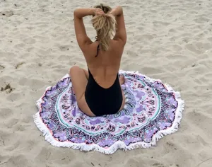 Ronde boho stranddoek met franjes en paars mandala patroon voor ontspannen dagen aan zee.