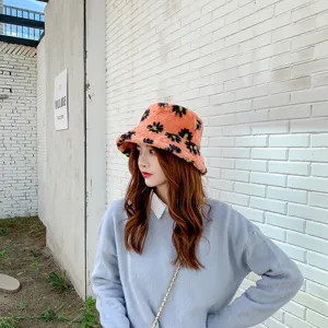 Soft fuzzy bucket hat detail, cute orange winter warm hat with black floral pattern.