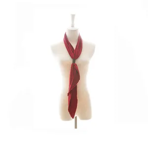 Detailed shot of a red pleated vintage scarf with a leather buckle, elegant neckerchief.