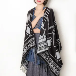 Detailed view of the black and gray geometric patterned knitted tassel shawl and poncho.
